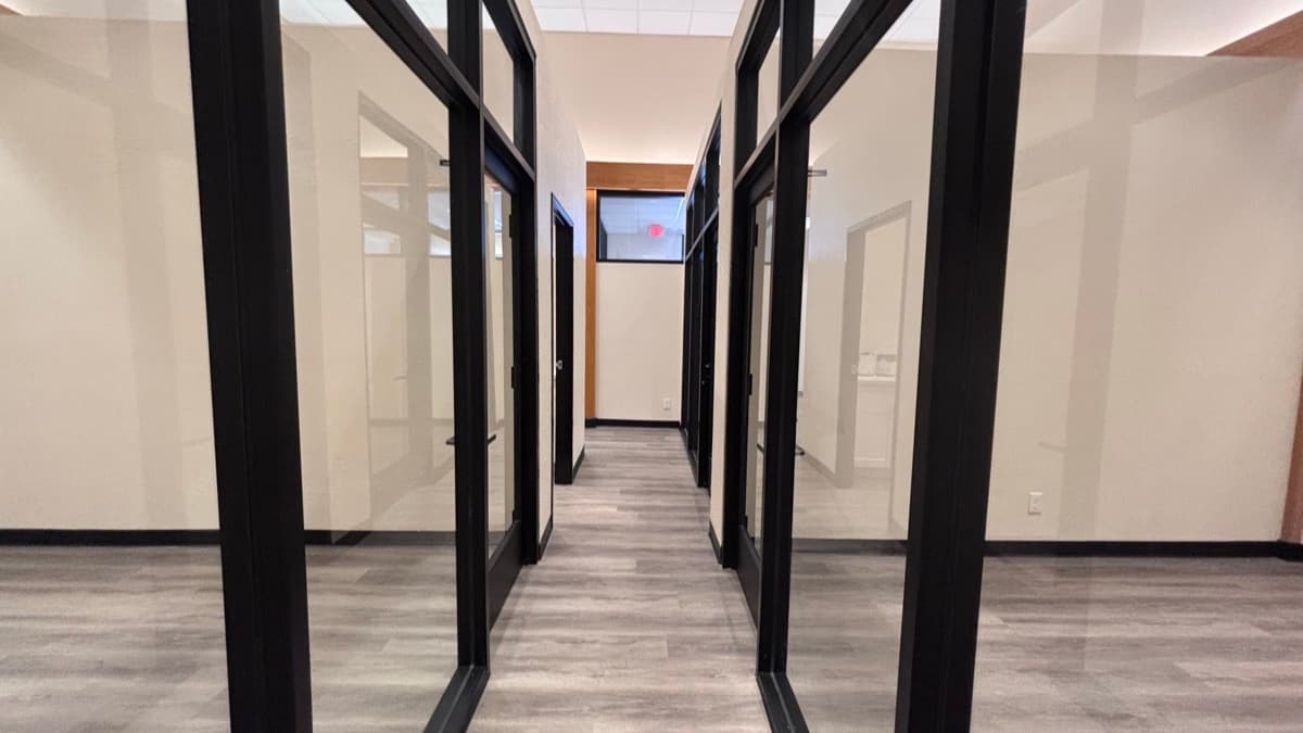 Black-framed glass office fronts along a commercial hallway