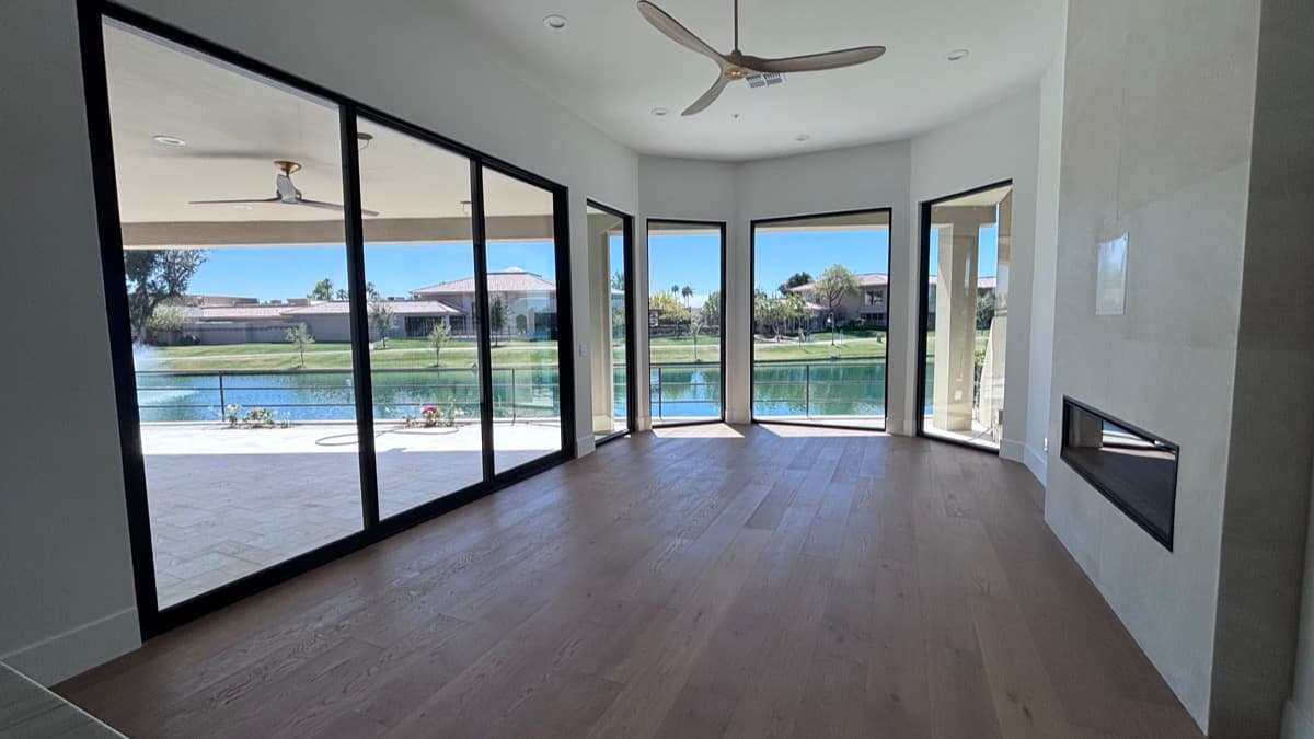 Multi-panel sliding glass doors opening onto a waterfront patio